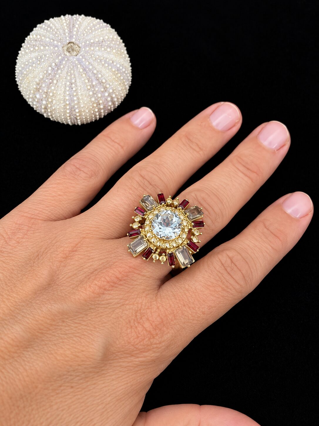 Anillo dorado y erizo marino sobre negro