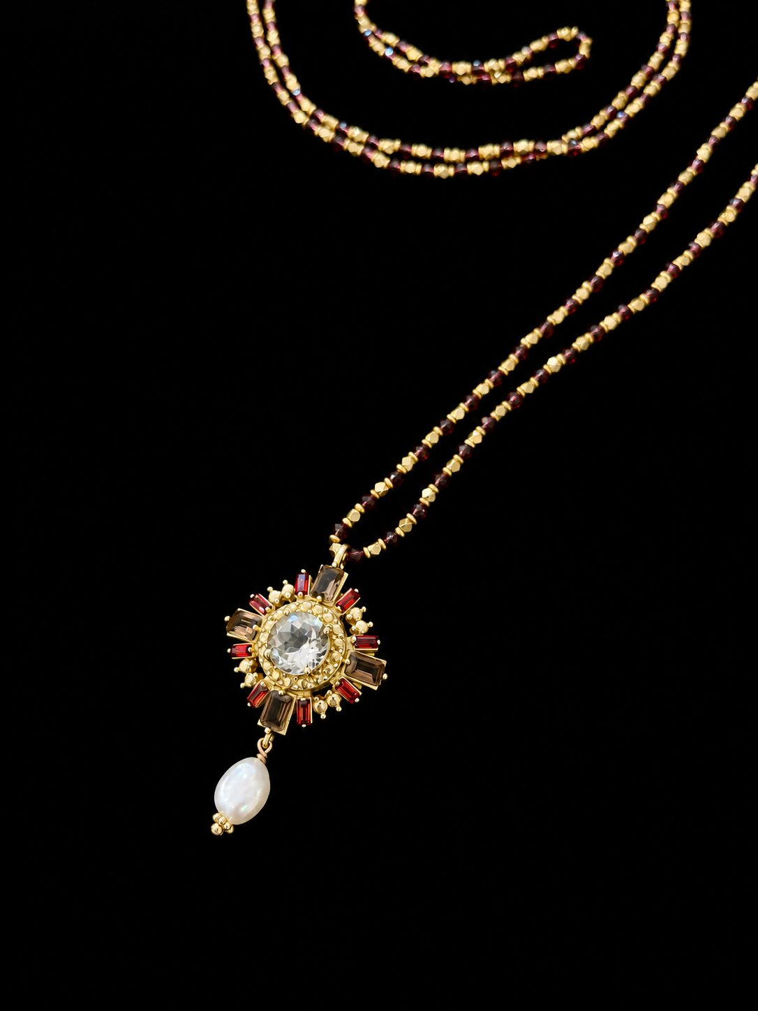 Collar dorado con medallón radiante y perla